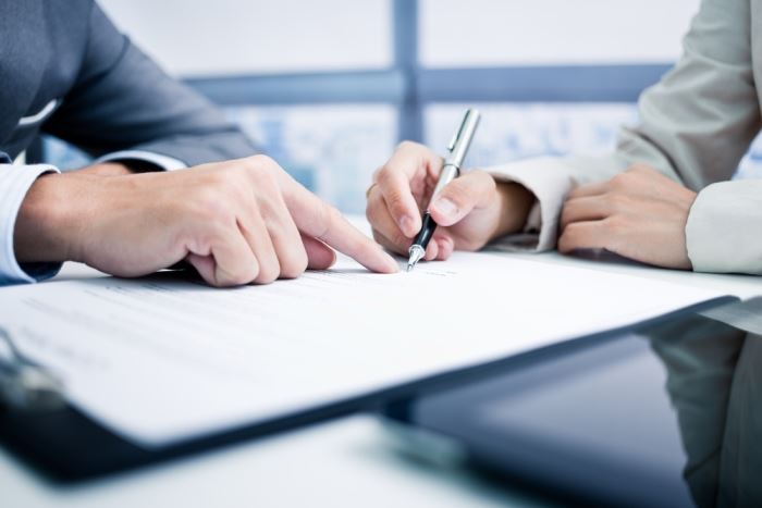 close-up of two business people's hands signing a contract